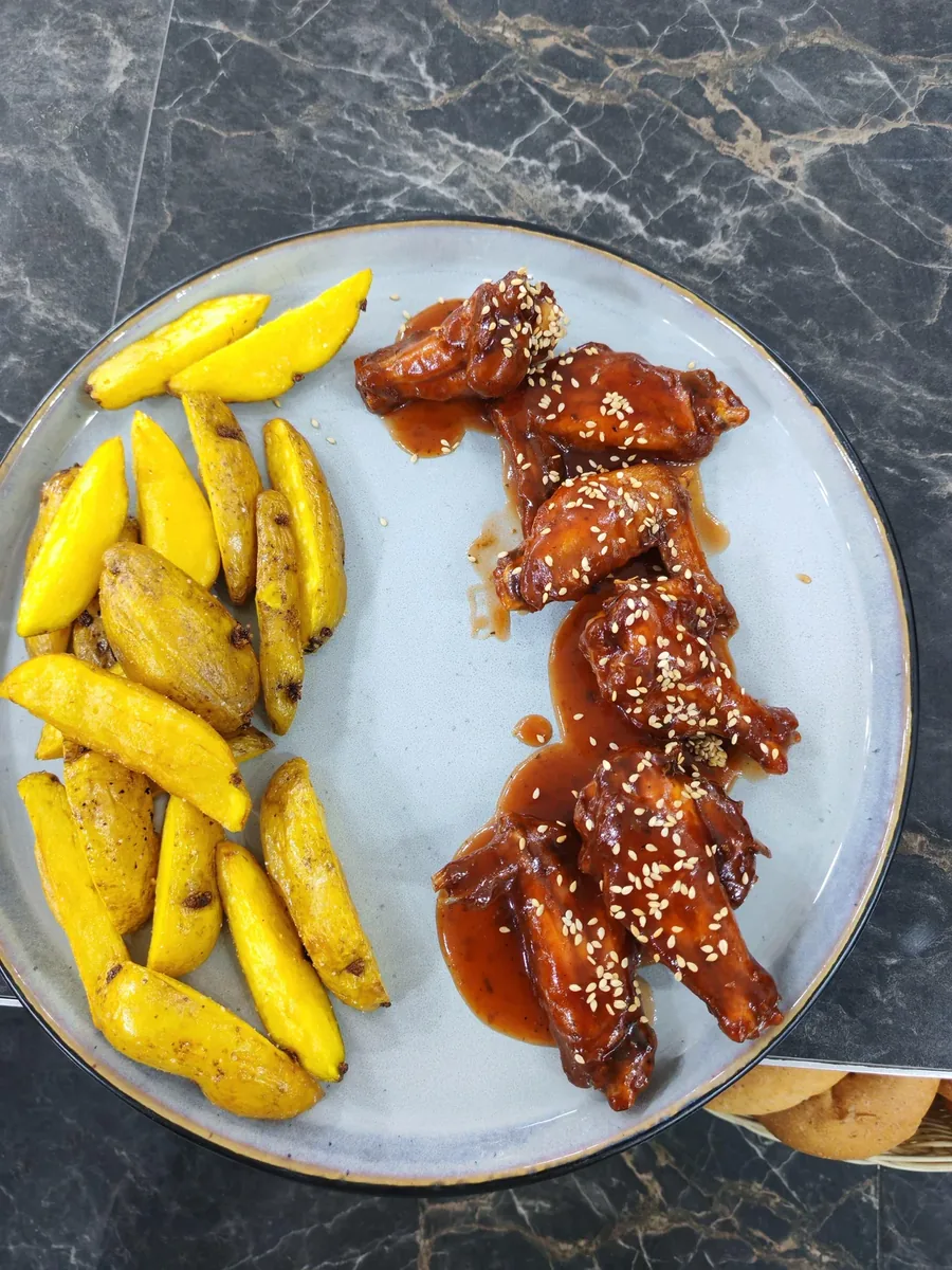 Alitas BBQ glaseadas con semillas de ajonjolí y papas rústicas en Guayusa
