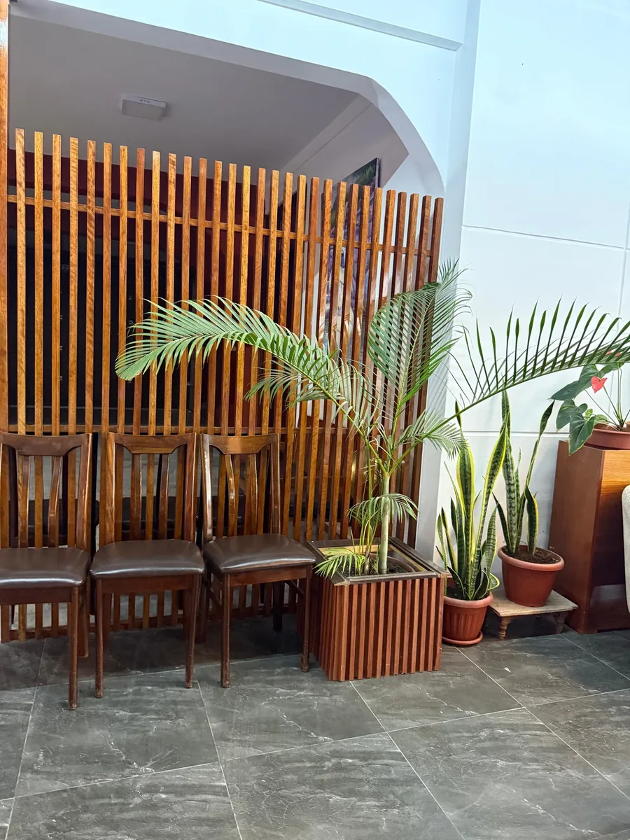Lobby y sala de descanso con plantas ornamentales y paneles de madera en Hotel Arenas del Mayo