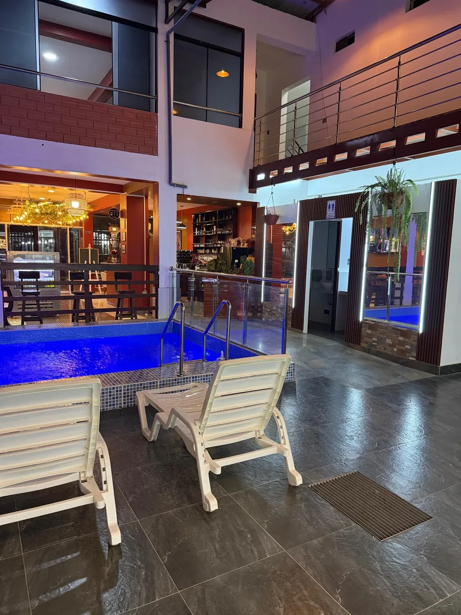 Piscina nocturna con iluminación azul y patio interior del Hotel Arenas del Mayo